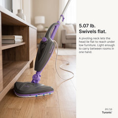 Gray and purple steam mop lying nearly flat on hardwood floor, head angled under a low wooden shelving unit.